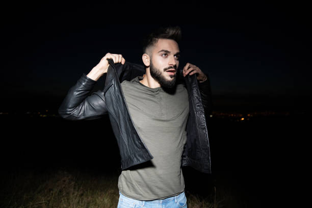 istock surprised man in leather jacket standing outside in the dark 1091324654