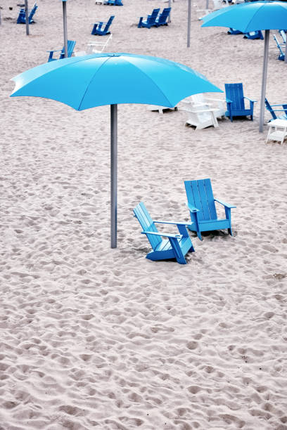 istock Blue plastic deck chairs and cyan plastic umbrella on the white sands of a beach 1091328198