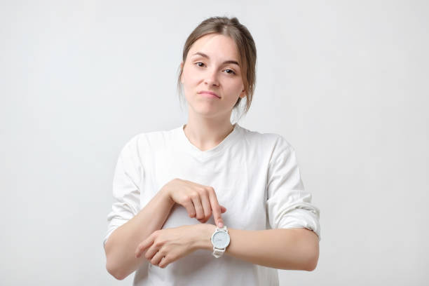 młody ładna kaukaska studentka jest zła, ponieważ jej chłopak jest spóźniony. - waiting women clock boredom zdjęcia i obrazy z banku zdjęć