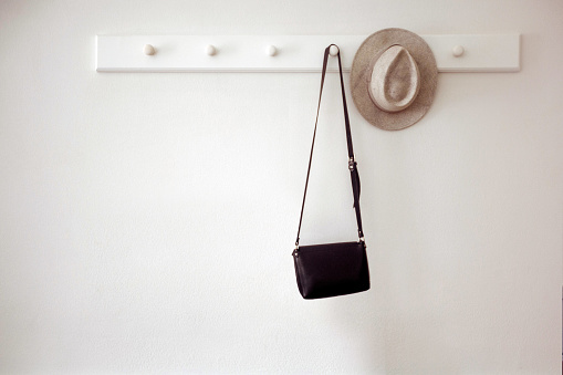 Sombrero y bolso colgando en las clavijas photo