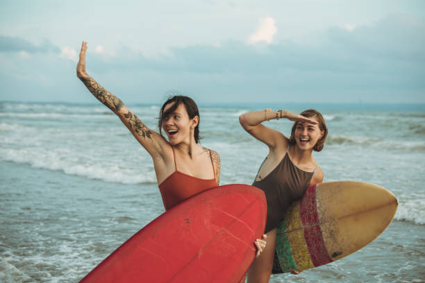 istock Beautiful women with surfboards going surfing together 1091332768