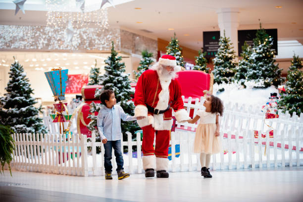 Shopping Christmas with family and Santa Claus at Shopping Mall Multi-Ethnic family shops at Shopping Mall during Christmas Time with Santa Claus. Santa Claus and children are walking hand by hand. Photo was taken in Quebec Canada. santa claus photos stock pictures, royalty-free photos & images