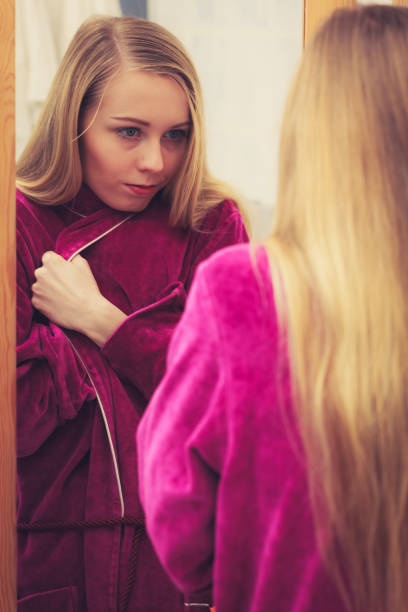 istock Woman looking at her reflection in mirror 1091339978
