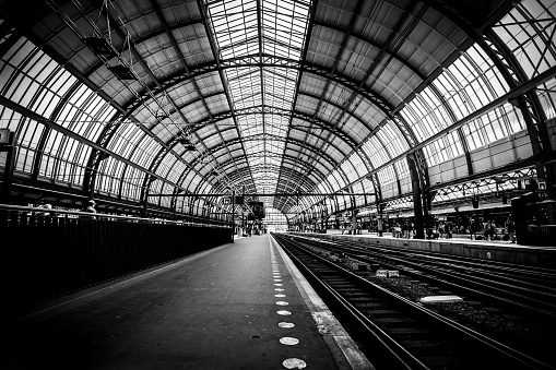 Platforms of the Amsterdam train station (Amsterdam Central Station - Centraal Station), Netherlands. Black and white image. Low key image