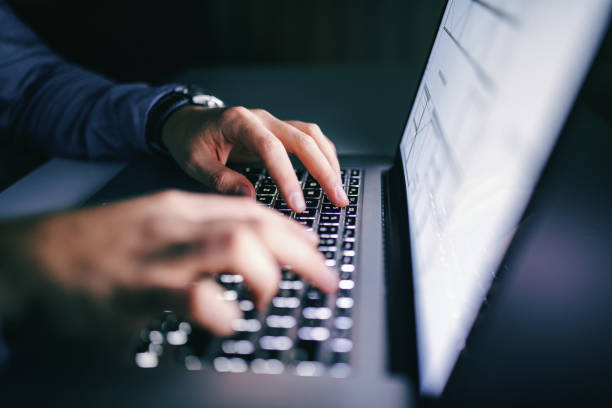nahaufnahme der hände tippen auf laptop. nachtarbeitskonzept. - computerkriminalität fotos stock-fotos und bilder