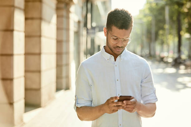 istock Young man using smart phone on sidewalk in city 1091357820