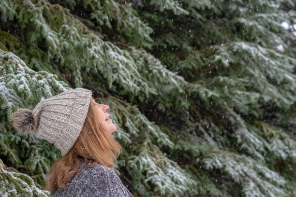 istock Woman looking up at falling snow 1091363634