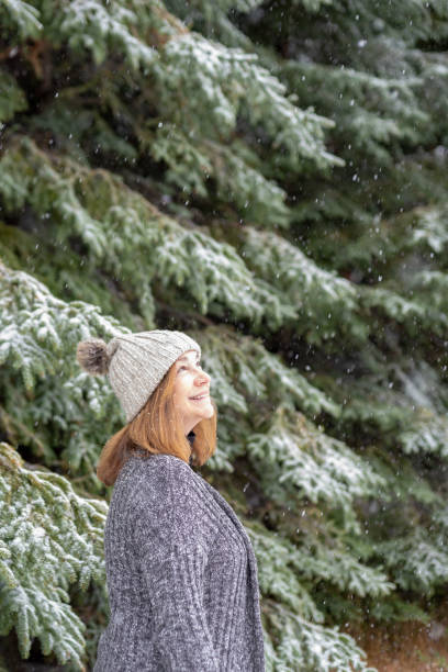 istock Smiling woman looking up at falling snow 1091363646