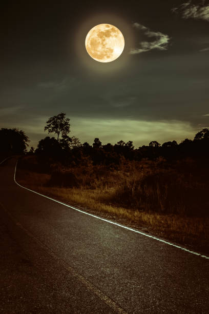 istock Dark sky with full moon and roadway through suburban zone. 1091368686