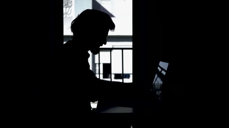 Side view of focused businessman working with laptop at home.