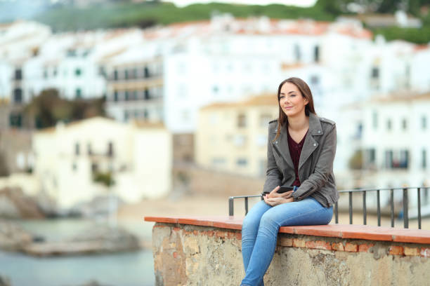 istock Woman contemplating ocean in a coast town 1091380888