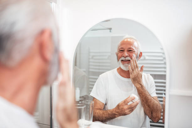 uśmiechnięty starszy mężczyzna uwodzenie brodę w łazience. - men shaving human face bathroom zdjęcia i obrazy z banku zdjęć