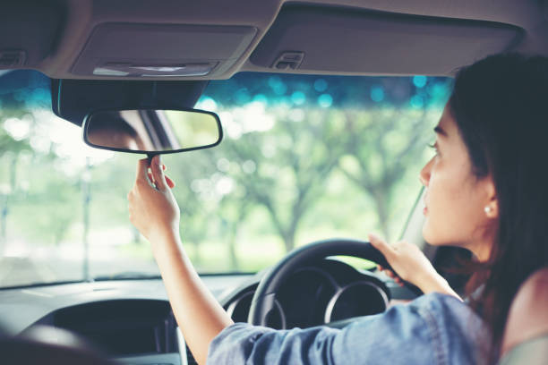 asiatische frauen sind die rückspiegel des autos einstellen. - rear view mirror car mirror rear view stock-fotos und bilder