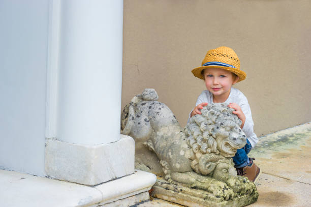 istock Little Boy and a lion cement statue 1091389568
