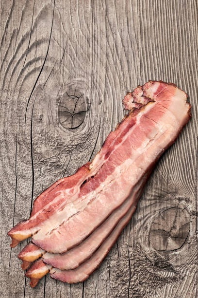istock Three Pork Bacon Rashers Set On Old Knotted Weathered Cracked Pinewood Picnic Table Rustic Rough Grunge Surface 1091391646