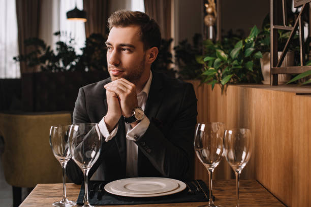 istock handsome man in suit waiting for girlfriend in restaurant 1091397712