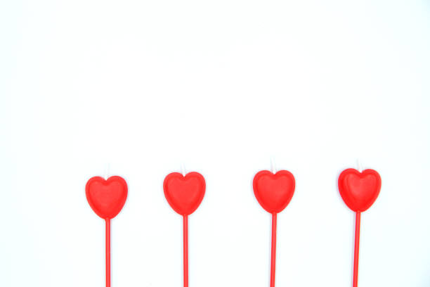 istock Four red heart shaped candles in a row isolated on white background. 1091400734