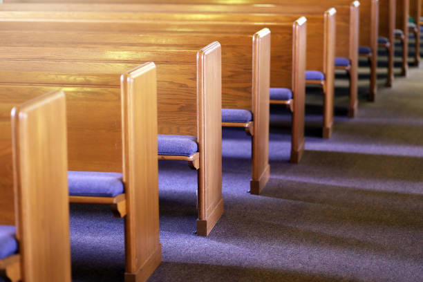 rows of church pews in an empty church sanctuary - pew imagens e fotografias de stock