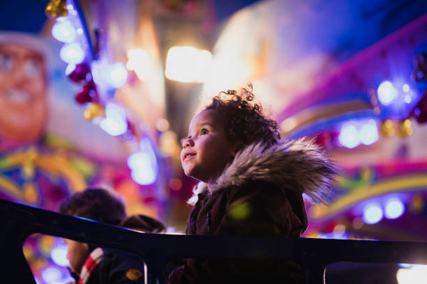 First Time at the Funfair A close-up shot of a little girl's first time at the funfair, she is looking at all of the decorations in awe. christmas excitement stock pictures, royalty-free photos & images