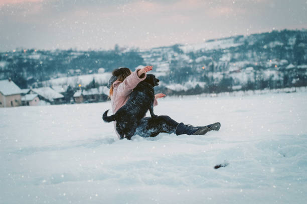 istock Woman and dog play in the snow 1091413402