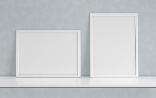 istock Poster frame mockup with blank copy space on grey background. Front view photo frame on white book shelf or desk. Digitally generated, 3d render 1091416018