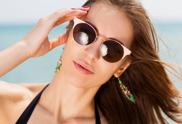 istock Sea. Face, sunglasses, earrings, hands manicure, close up 1091416248