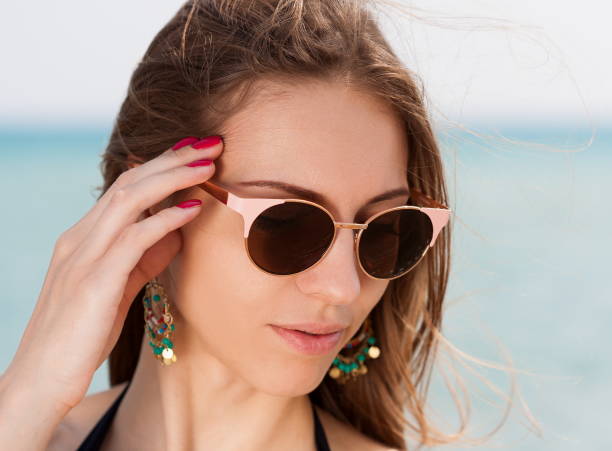 istock Sea. Face, sunglasses, earrings, hands manicure, close up 1091416264
