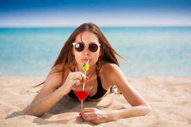 istock Sea. Black bikini sea drink cocktail, close up, sand 1091416928
