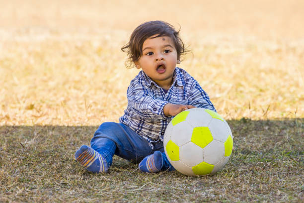istock baby boy playing with a ball in the park 1091423626