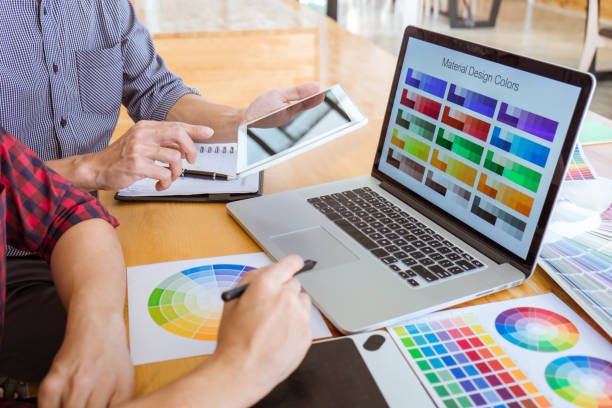 istock Teamwork of young creative designers working on project together and choose color swatch samples for selection coloring on digital graphic tablet at workspace 1091423656