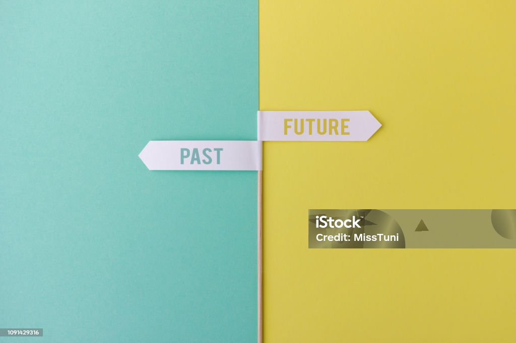 Small post with flags showing future and past Wood stick with small white flags on yellow and blue background showing past and future Change Stock Photo