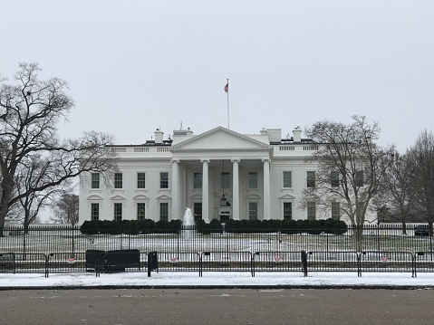 Washington DC,USA - January 4,2018:Pennsylvania Street and the snowy white house where the snow that fell the previous day was snow-removed. Because President is at home Pennsylvania street is closed and tourists are lowered to the snowy remaining Lafayette Square.