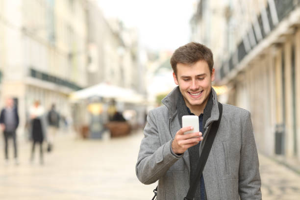 istock Happy man walking checking smart phone in the street 1091431146