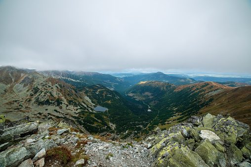 rocky Tatra mountain tourist hiking trails under blue sky and occasional mist  cloud in Slovakia, path to Volovec mountain