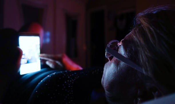 istock Elderly Senior woman lying on bed using mobile phone - low key 1091444392