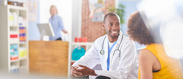 doctor discussing medication with female customer with checkout counter in the background