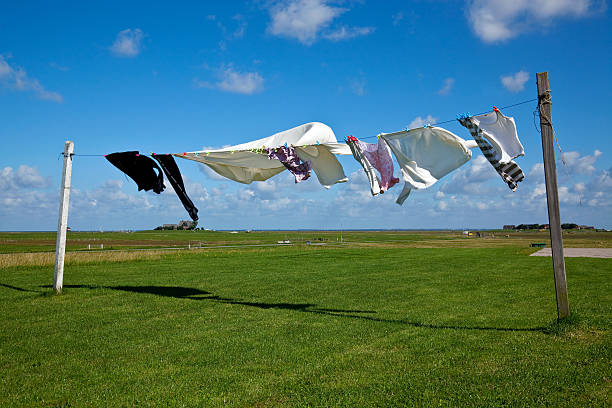 wet laundry drying on clothes line against a blue sky