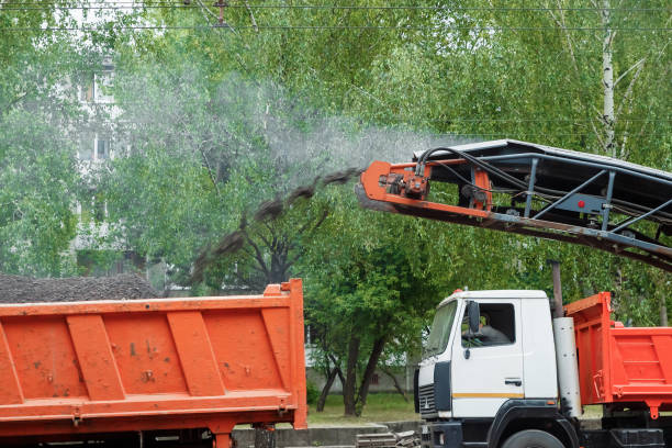 istock The machine is cutting asphalt, cutting old asphalt with a special machine and loading it into a dumper on a summer day. Repair of roads, replacement of asvalt, construction work. 1091463366