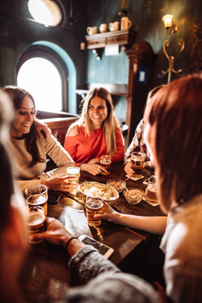 pessoas falando dentro de casa em um pub com as cervejas - pub food - fotografias e filmes do acervo