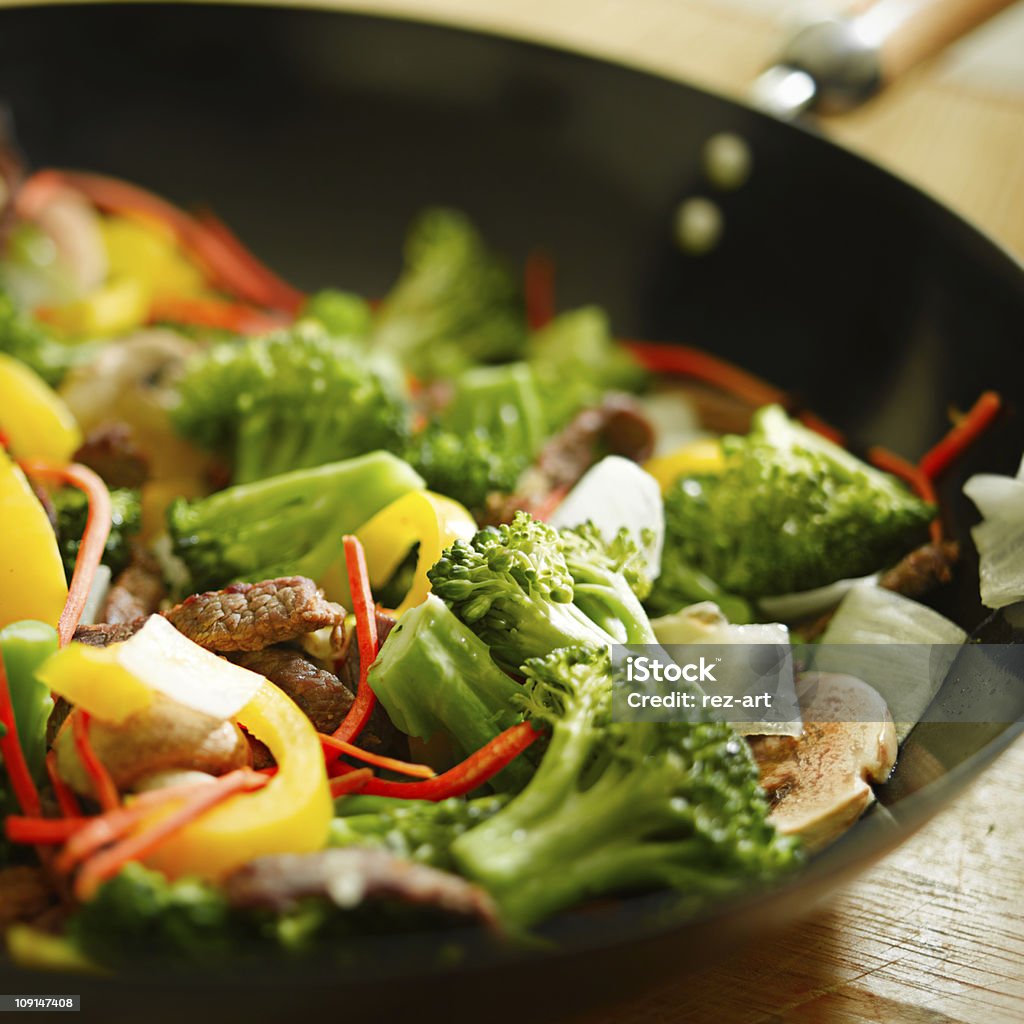 Beef wok stir fry with vegetables Beef wok stir fry with vegetables  such as brocoli, yellow bells peppers, mushroom, onion, and carrots.  (note- selective focus) Beef Stock Photo
