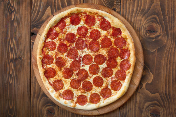 istock Pizza pepperoni with tomatoes, bacon and olives, top view 1091475578