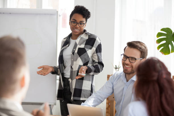 istock Diverse employees laugh during flipchart presentation at meeting 1091483186