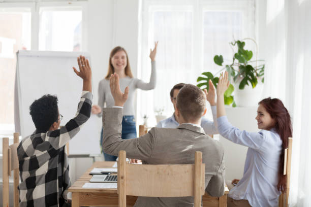 istock Diverse employees raise hands participating in teambuilding 1091483238