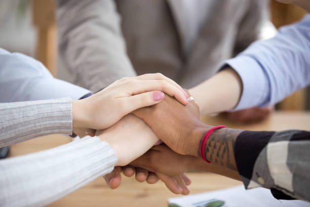 istock Close up of diverse people join hands in stack together 1091483314