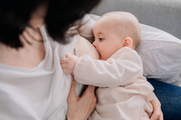 Madre che allatta la figlia - foto stock