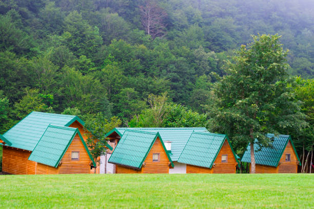 Traditional camping cabins on the lawn near mountain