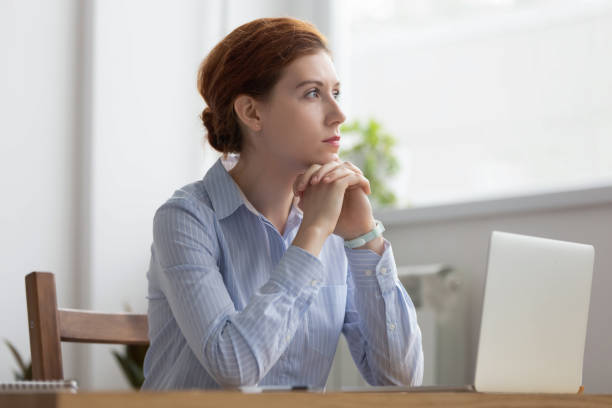 istock Lost in thoughts woman sits at workplace desk in office 1091491614