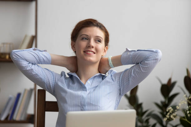 istock Female sitting in office holding hands behind the head 1091491638