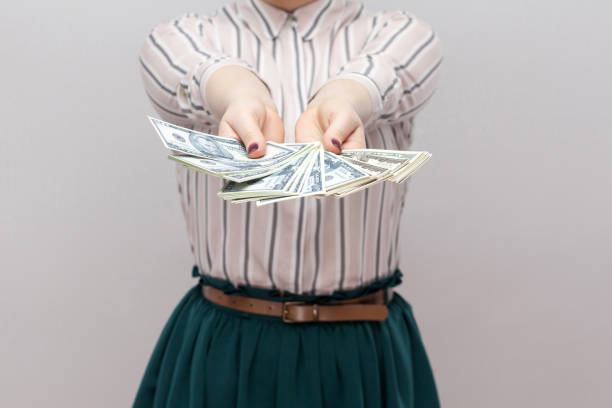 ¡tómalo! retrato de mujer exitosa en pie de camisa a rayas, con muchos dólares, ventilador de la demostración de dinero de cerca. - generosidad fotografías e imágenes de stock