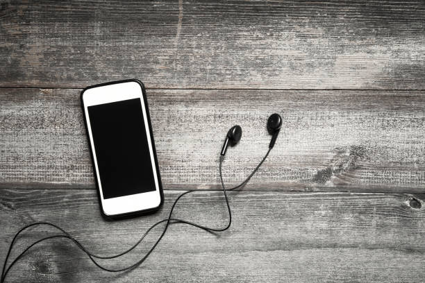 istock Mobile phone with earphone on wooden background 1091495014